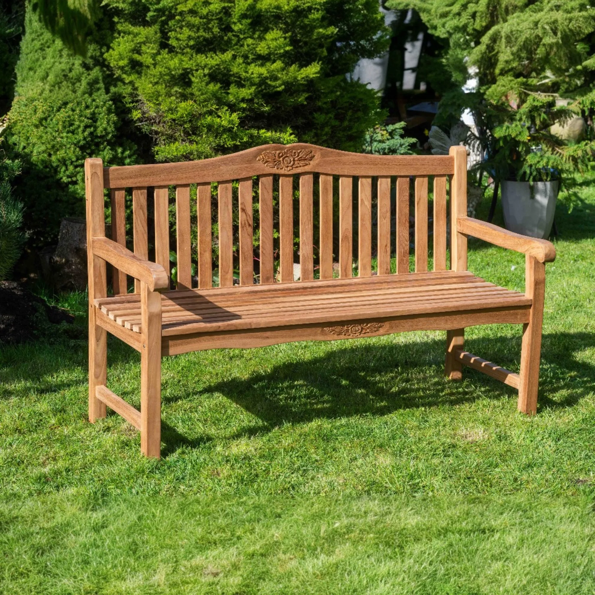 Angled view of the teak bench showing the scrolled back and shaped arms